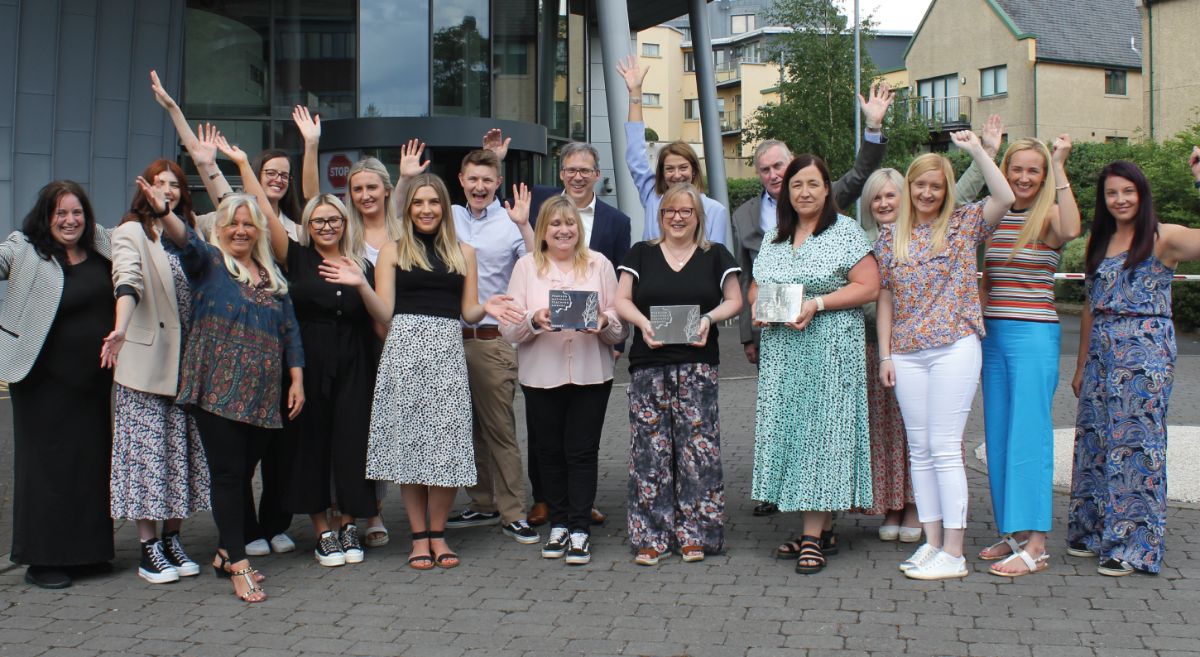 Group of happy SERC staff outside SPACE Bangor Campus cheering